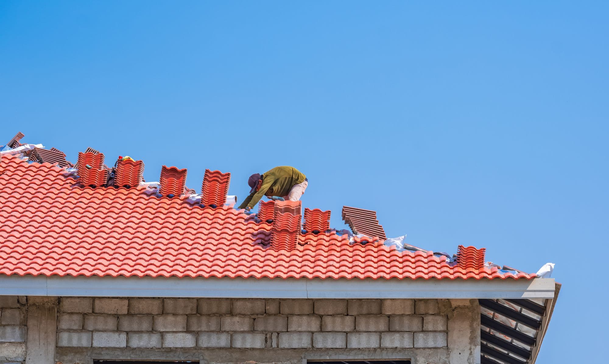 Roofer working on a red tile roof
